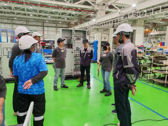 Engineers reviewing electrical cabinets on a workshop floor