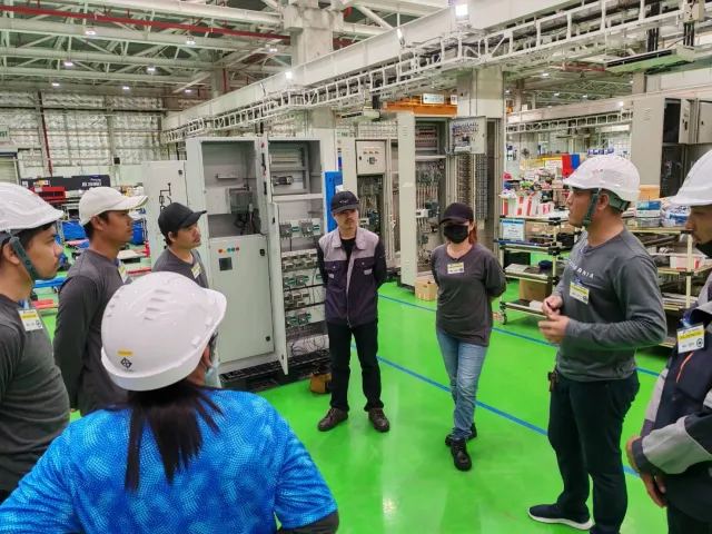 Engineering team discussing electrical cabinet assembly