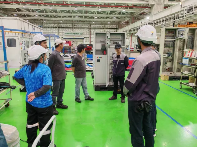 Engineers reviewing switchboard equipment in a workshop