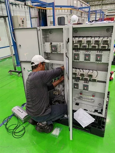 Technician working on electrical equipment in a workshop