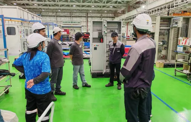 Engineering team reviewing equipment in an electrical workshop