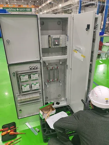 Technician examining an open control cabinet
