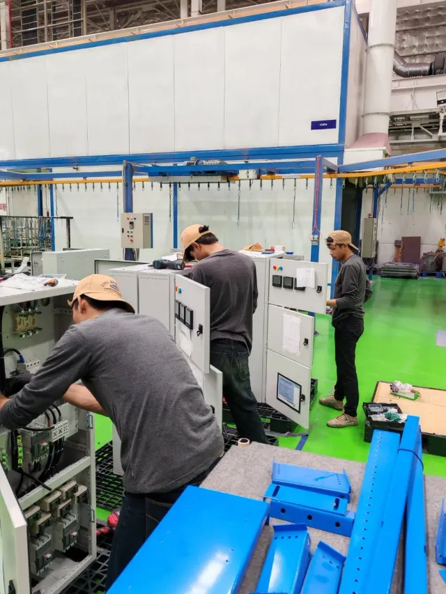 Technician assembling electrical equipment on the workshop floor