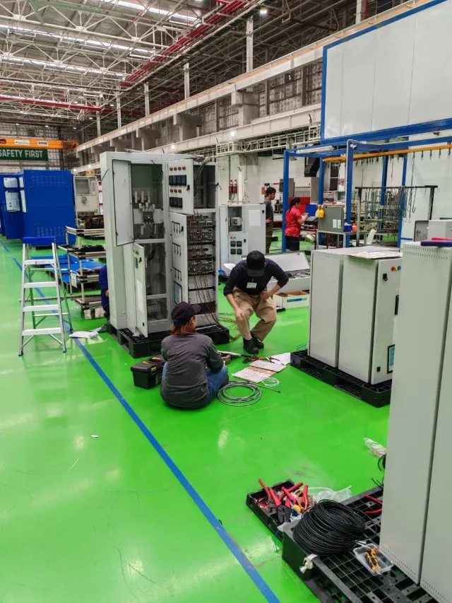 Electrical cabinets and technicians in a workshop