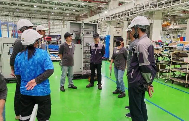 Engineers discussing electrical equipment in a workshop